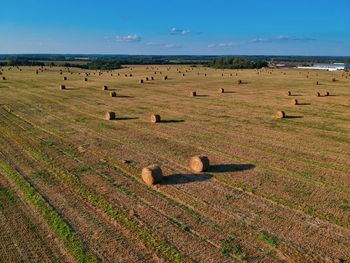 Hay bales on field against sky