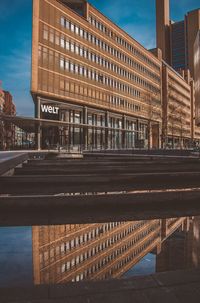 Road by building against sky in city