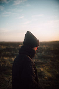 Side view of man looking at sunset