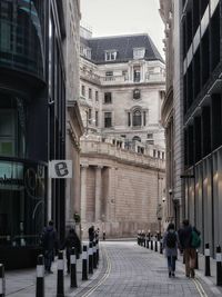 People walking on street amidst buildings in city