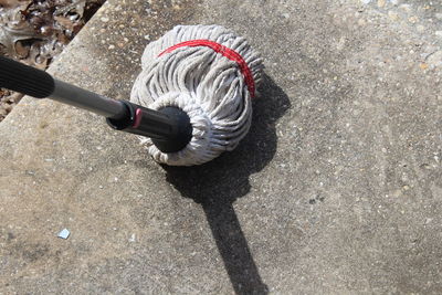 High angle view of mop on footpath during sunny day