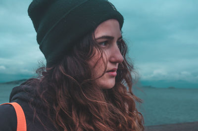 Woman looking away against sea