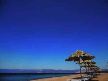 Scenic view of beach against clear blue sky