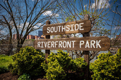 The south side riverfront park sign against the backdrop of downtown pittsburgh, under a clear sky.