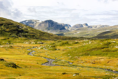 Scenic view of mountains against cloudy sky