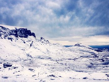 Snow covered mountains against cloudy sky