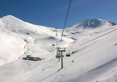 Overhead cable car in snowcapped mountains against sky