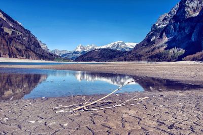 Scenic view of lake and mountains against clear blue sky