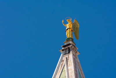 Low angle view of statue against blue sky