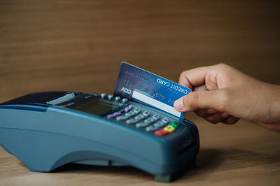 Close-up of person holding mobile phone on table