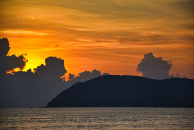 Amazing wonderful dramatic golden colored sky behind the clouds during a stunning sunset in langkawi