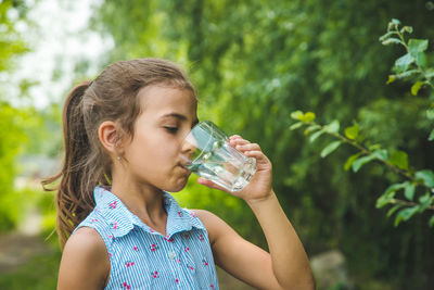 Side view of girl drinking water from glass