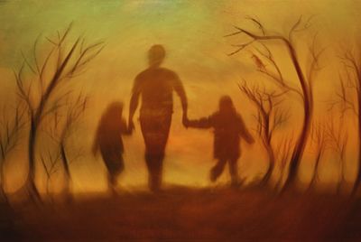 Silhouette people on field against sky during sunset