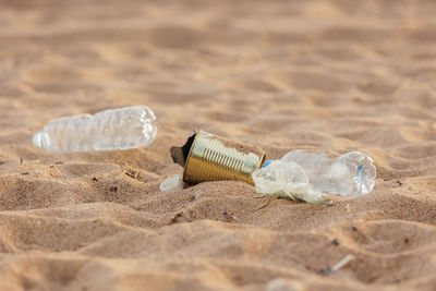 Close-up of water bottle on sand at beach
