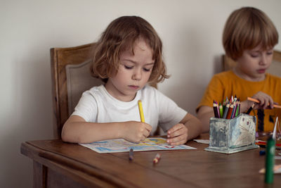 Siblings sitting on table