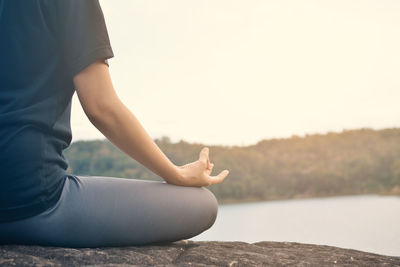 Midsection of woman sitting outdoors