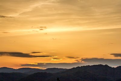 Scenic view of mountains against orange sky during sunset