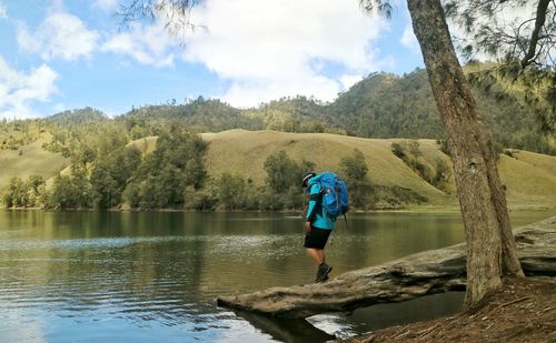 Man standing by lake against sky