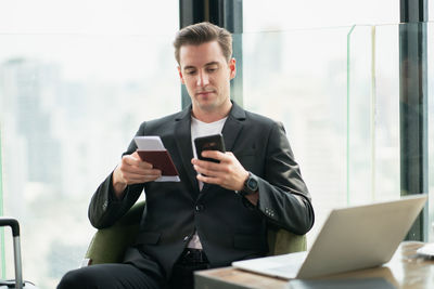 Young man using mobile phone in office