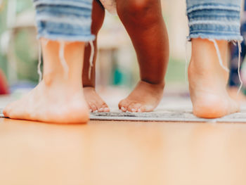 Low section of mother and son walking on road