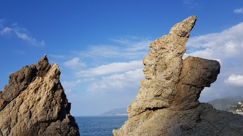 Panoramic view of rocks and sea against sky