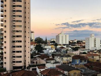 Buildings in city against sky during sunset