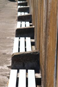 Looking down onto a row of wooden benches against a harbour wall