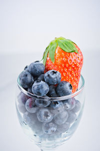 Close-up of fresh fruits in bowl against white background