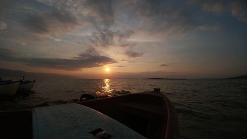 Cropped image of boat in sea at sunset