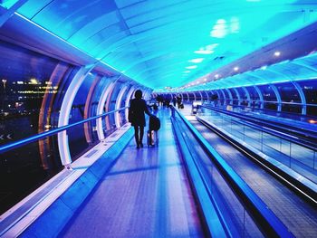 Man on illuminated underground walkway