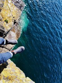 Low section of man on rock over sea