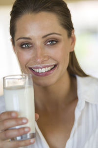 Portrait of smiling woman drinking milk