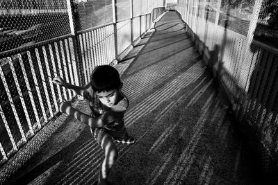 High angle view of boy jumping on footpath