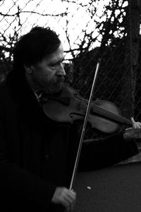 Mature man playing violin at dusk