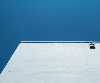 Low angle view of airplane against clear blue sky