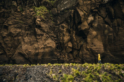 Side view of woman walking by rock formations