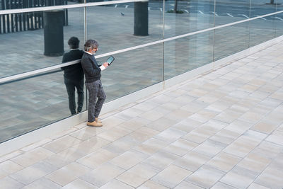 Mature handsome business man using a digital tablet outside office building