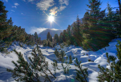 Scenic view of snowcapped mountains against bright sun