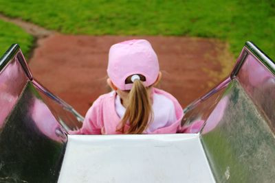 Rear view of girl on slide at playground