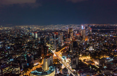 High angle view of illuminated cityscape against sky at night