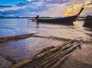 Boat moored on beach against sky