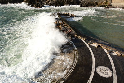 High angle view of waves splashing on sea