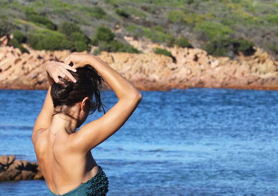 Young woman standing against sea at beach