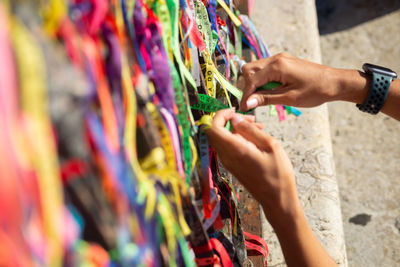 Catholics and tourists are seen tying a souvenir ribbon on the iron railing of the church