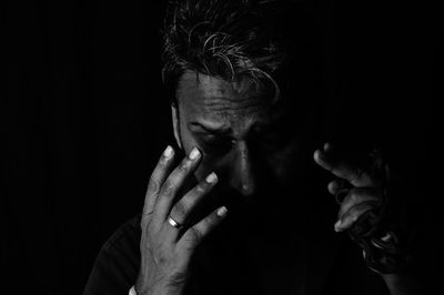 Close-up portrait of man against black background