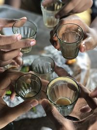 Midsection of people holding tea glass in rainy season