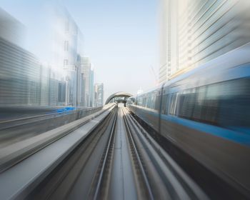 Railroad tracks in city against clear sky