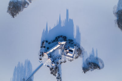 Aerial view of houses amidst snow covered landscape during winter