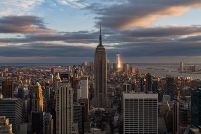 Aerial view of cityscape against cloudy sky