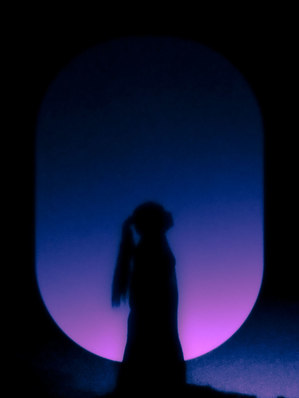 REAR VIEW OF SILHOUETTE WOMAN STANDING AGAINST DARK SKY